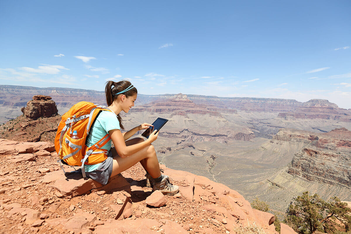 backpacker holding iPad at Grand Canyon