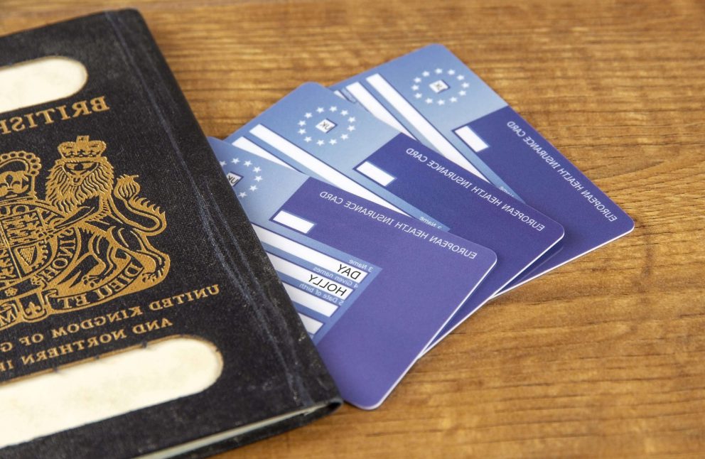 A EHIC and GHIC placed next to a passport